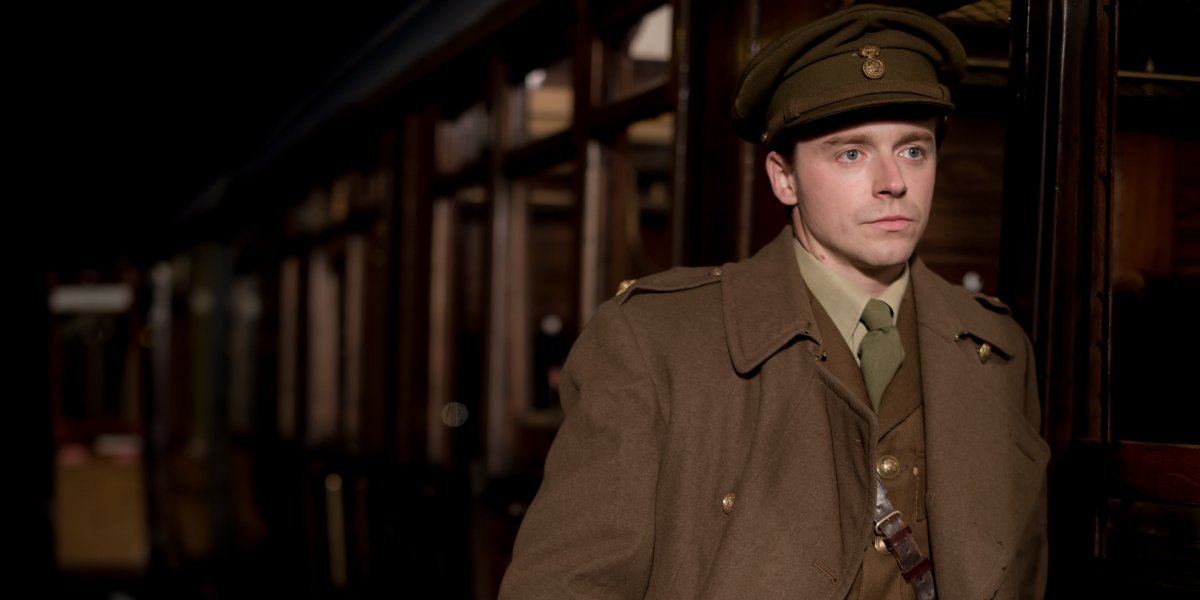 Jack Lowden boarding a train in uniform in Benediciton.