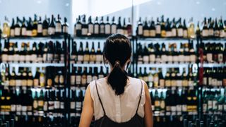 woman looking at wine selection in supermarket