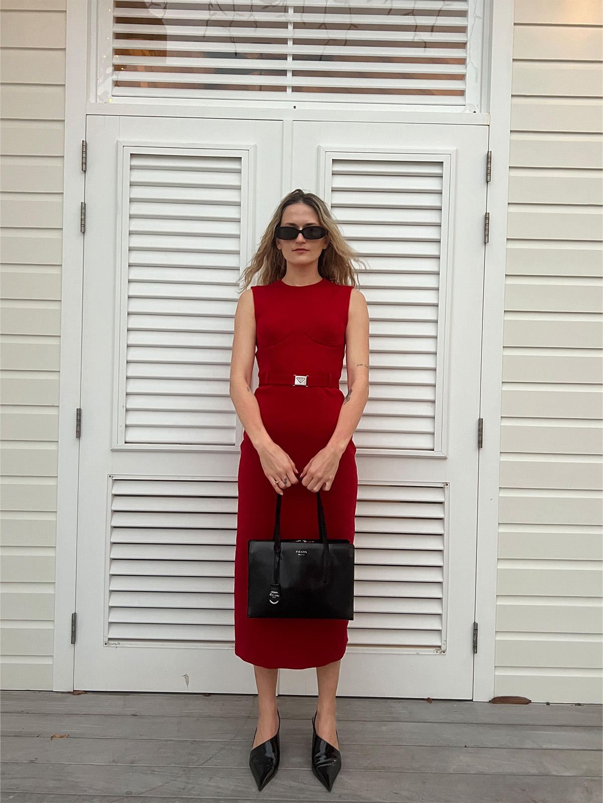 Eliza Huber wearing a red Prada dress with black Prada shoes and bag.