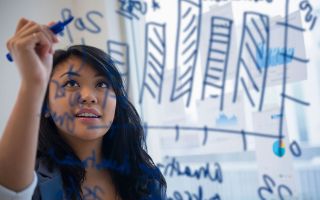 Image of a woman writing on a board