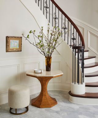 Entryway with staircase and table with floral display