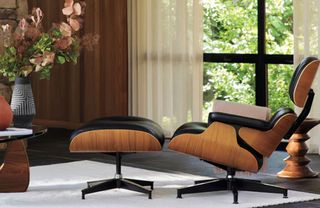 Eames lounge chair in living room, dark wood frame, black leather, rug on stone flooring