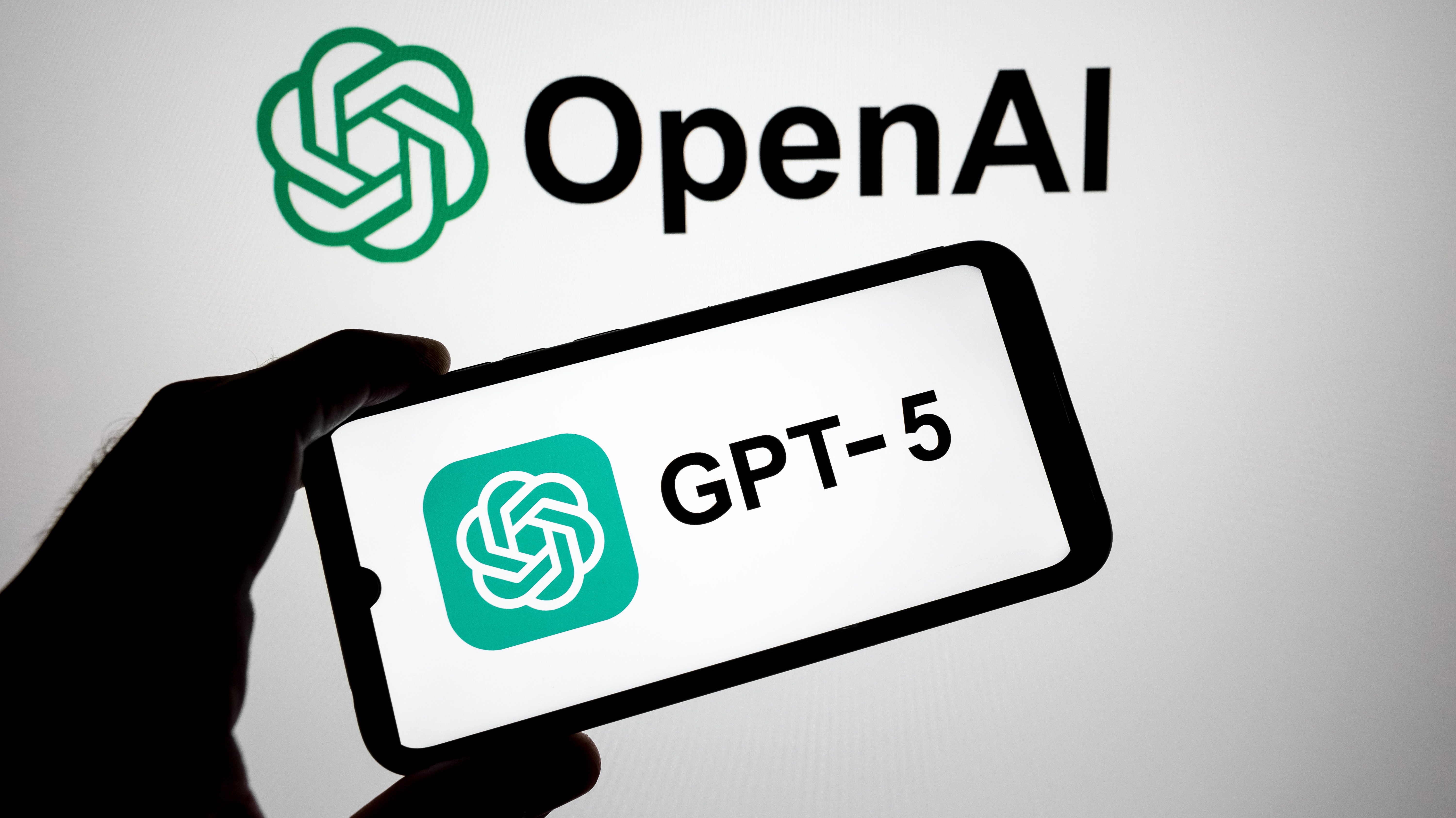 The ChatGPT-5 logo appears on a smartphone screen, and the OpenAI logo is the background.