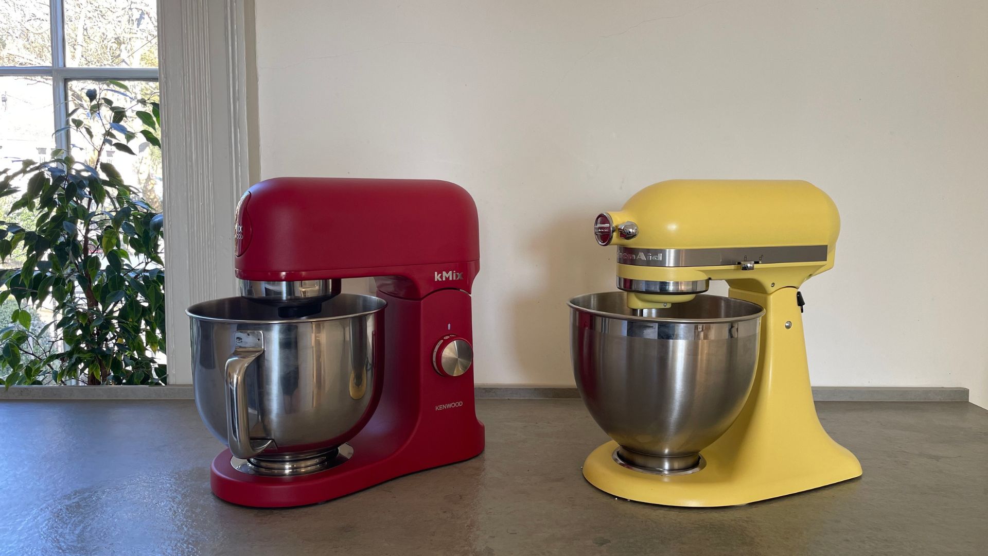 Kenwood kMix next to the KitchenAid Butter Yellow Stand Mixer
