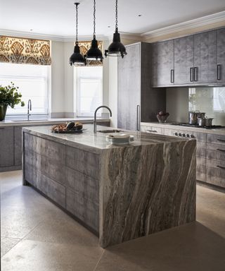 A kitchen with large natural stone style island and diagonal kitchen floor tile ideas.