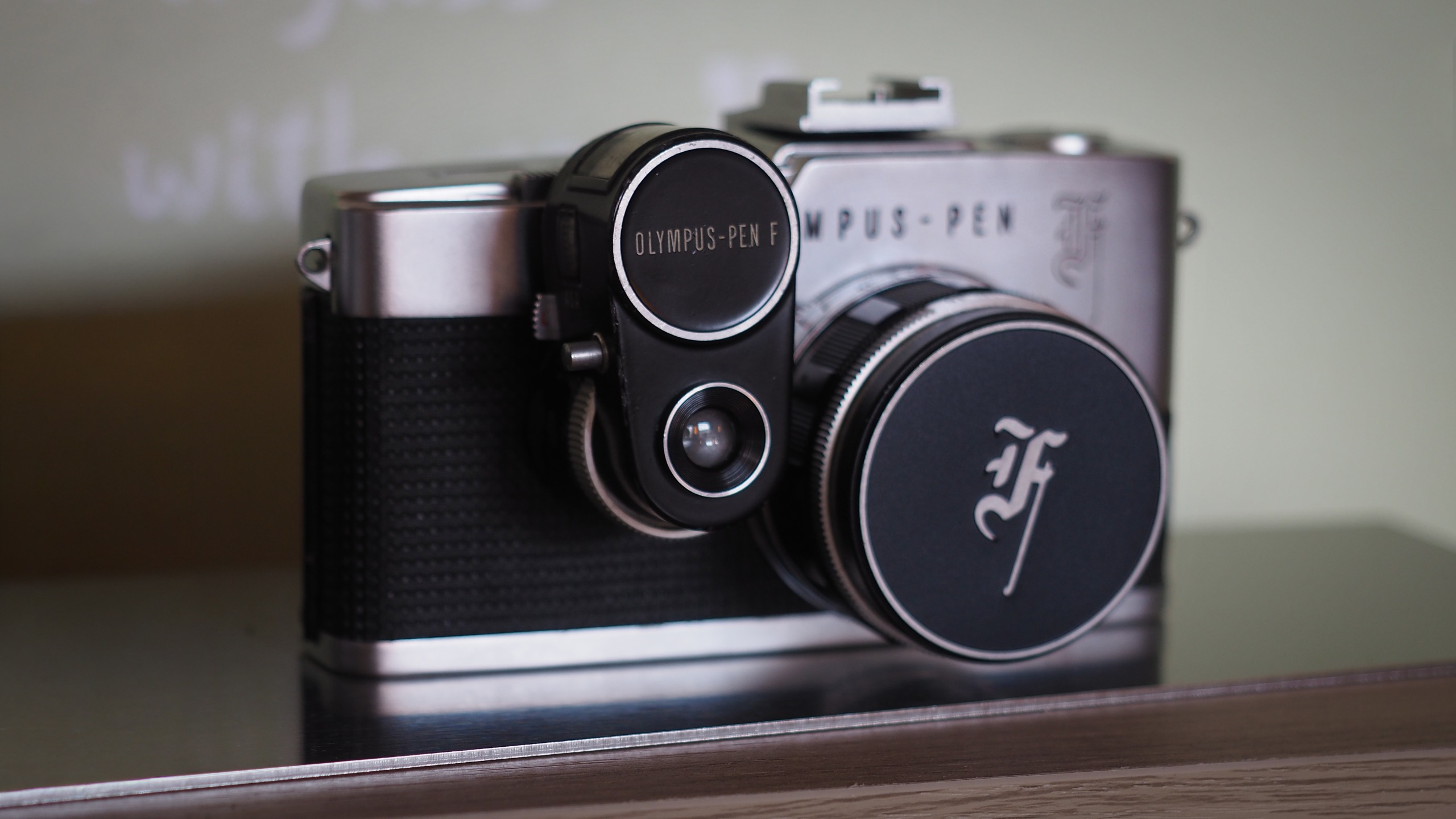 Olympus PEN-F (analog) on a metallic surface