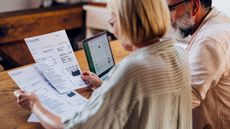 Couple look at energy bills beside laptop