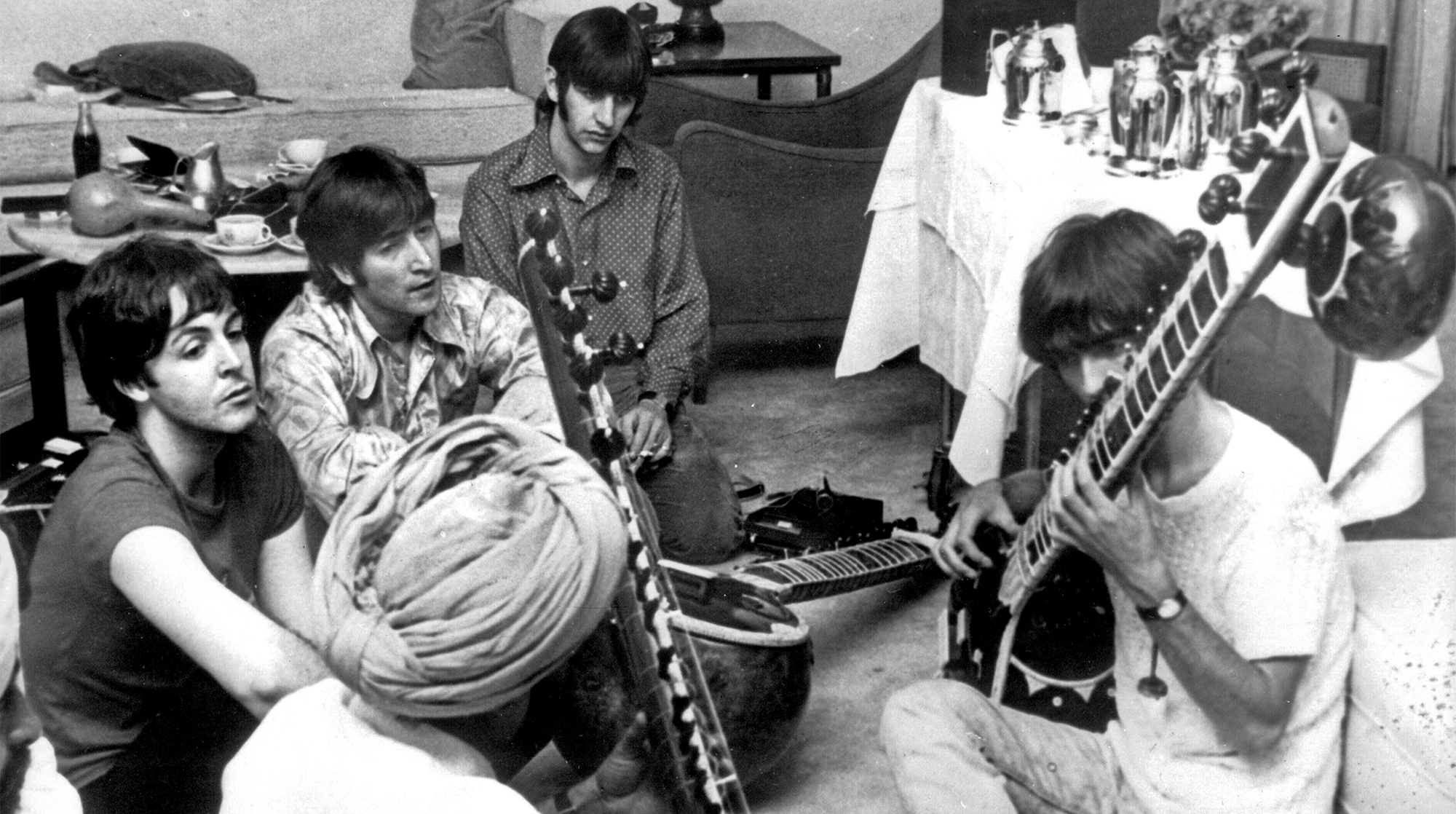 George Harrison receiving a sitar lesson in New Dehli, India. Watched on by Paul McCartney, John Lennon and Ringo Starr. 7th July 1966
