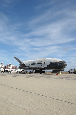 A recovery crew team works to process the U.S. Air Force's X-37B space plane after the robotic spacecraft's successful landing at Vandenberg Air Force Base in California on Oct. 17, 2014. It was the third X-37B mission for the Air Force.