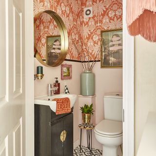 Downstairs cloakroom with pink wallpaper and art on wall