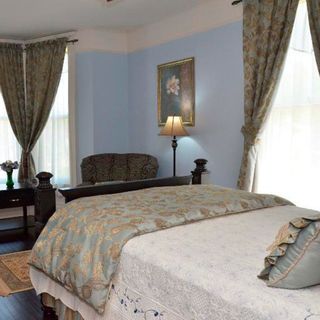 bedroom with wooden flooring and window curtain