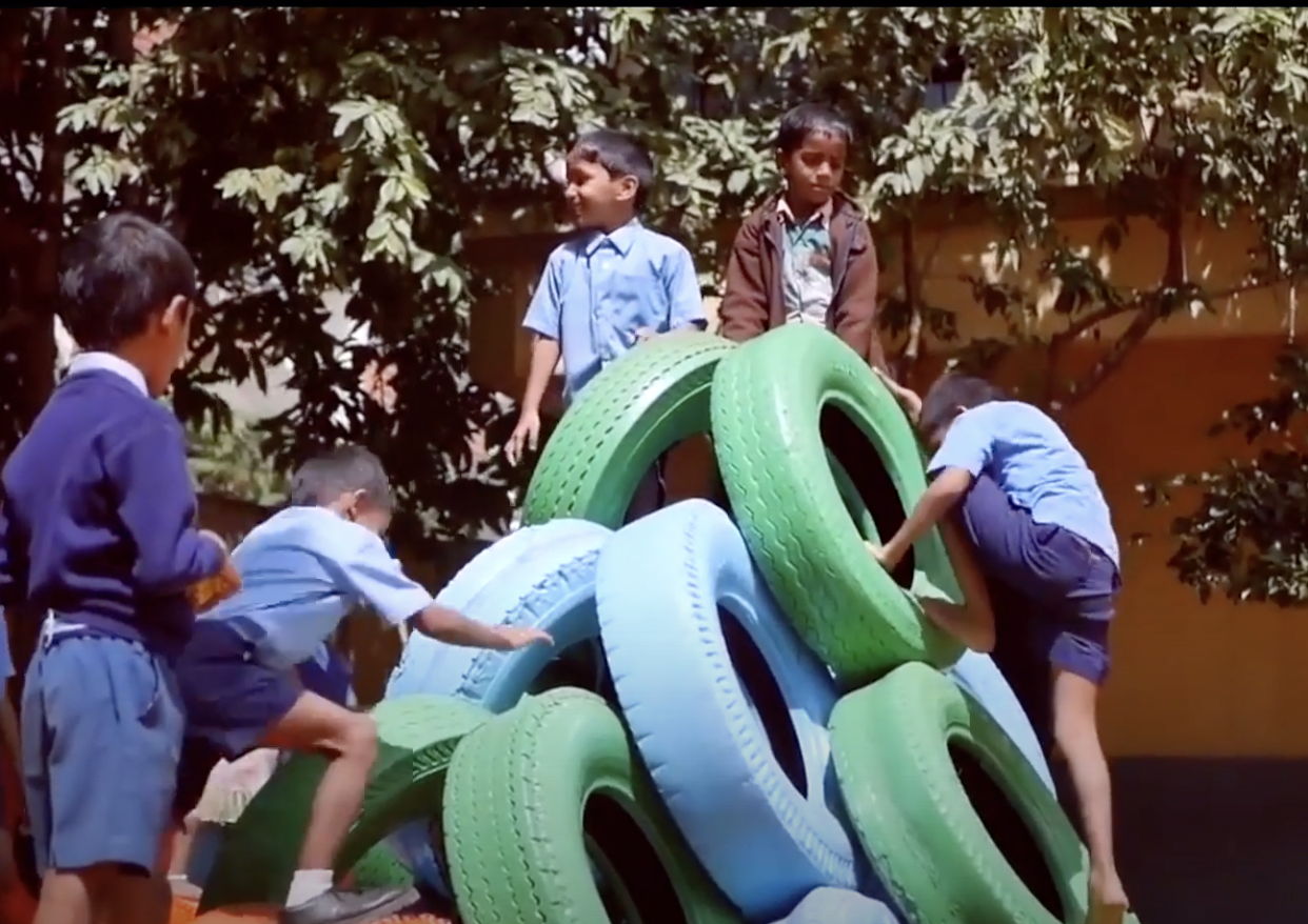 Kids play on their new tire playground equipment.