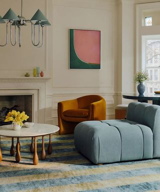 living room from the anthropologie Artful Aesthete collection for spring 2025 with soft blue modular furniture and a striped rug