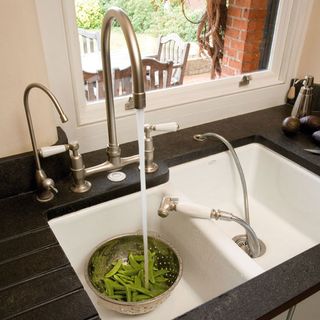 kitchen area with black worktop and sink and tap