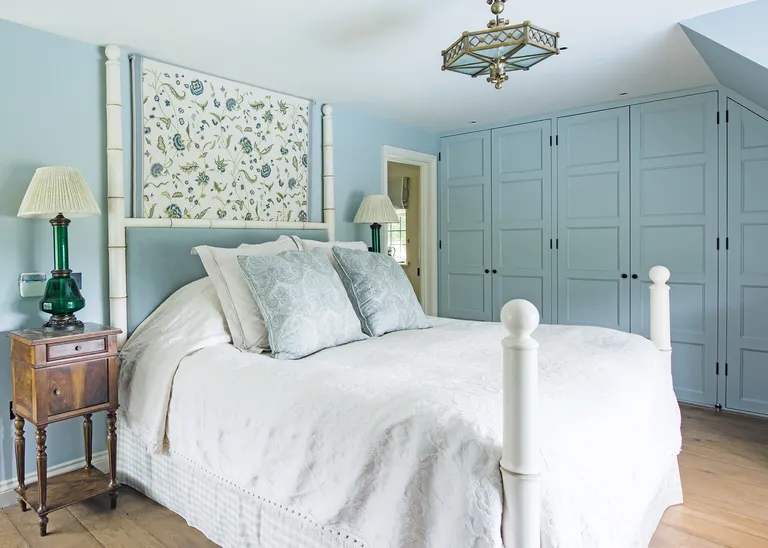 Cottage bedroom ideas - blue attic bedroom with fitted cupboards in cottage bedroom style