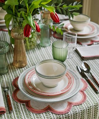 Pink mat, green and white table cloth, green and orange glasses