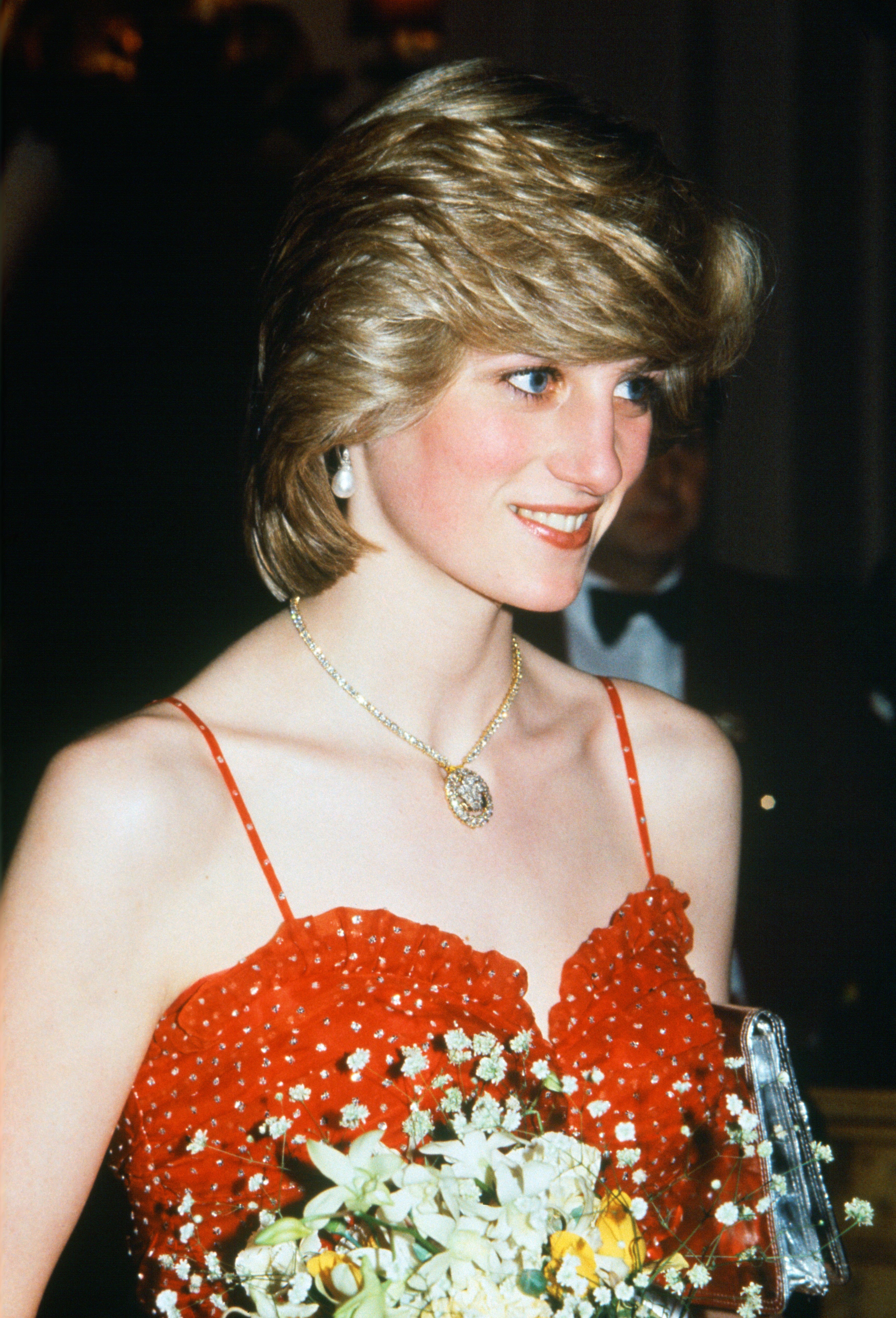 Princess Diana wears a red dress and the Queen Alexandra Three-Feather Brooch