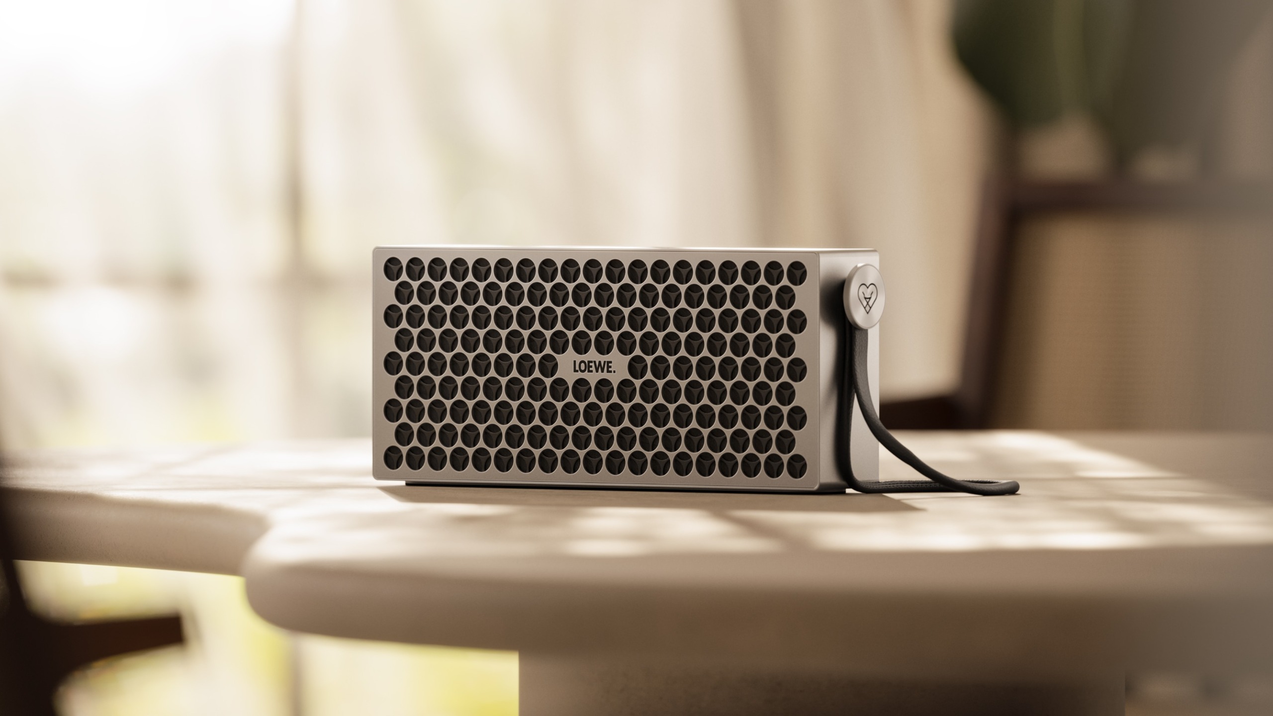 Loewe Neo Bluetooth speaker in a bougee setting 