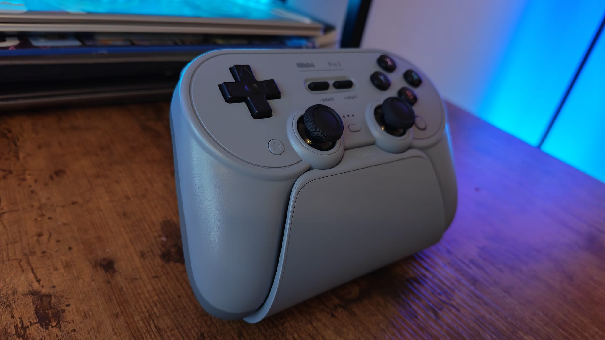 A grey 8BitDo Pro 3 on its charging stand