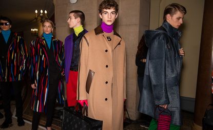 Five male models wearing clothing by Berluti in colourful shades.