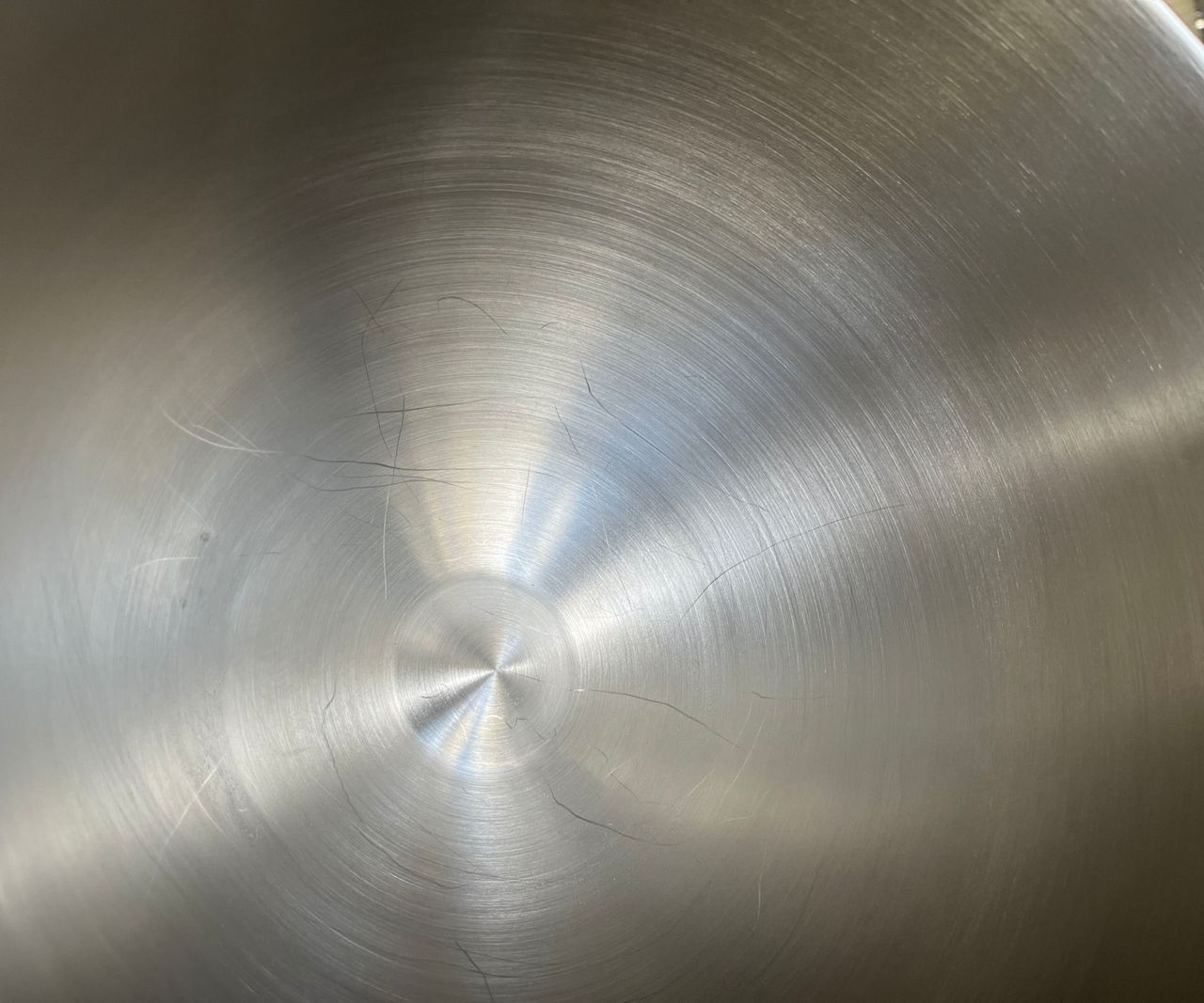 A close up of scratches in the SMEG Forte Stand Mixer stainless steel bowl.
