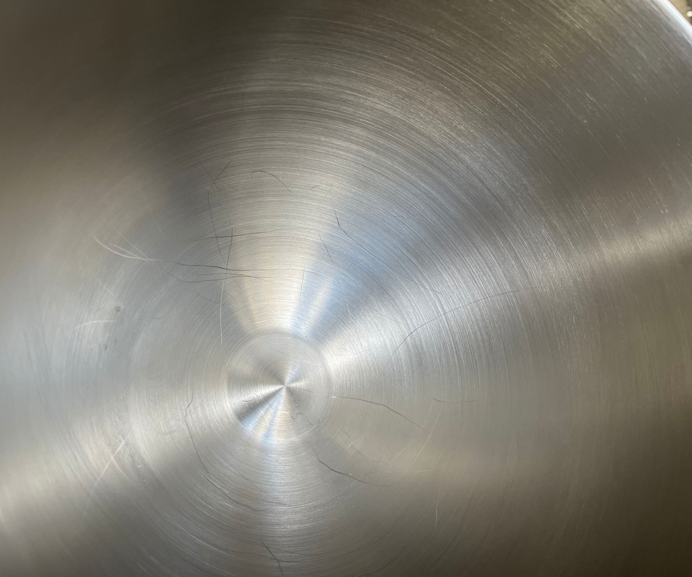 A close up of scratches in the SMEG Forte Stand Mixer stainless steel bowl.