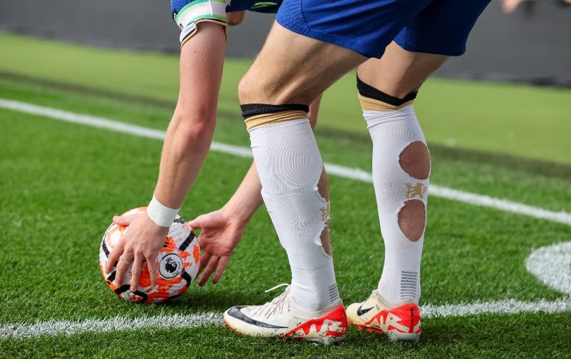 Why do so many footballers cut holes in their socks? Conor Gallagher preparing to take a free kick for Chelsea