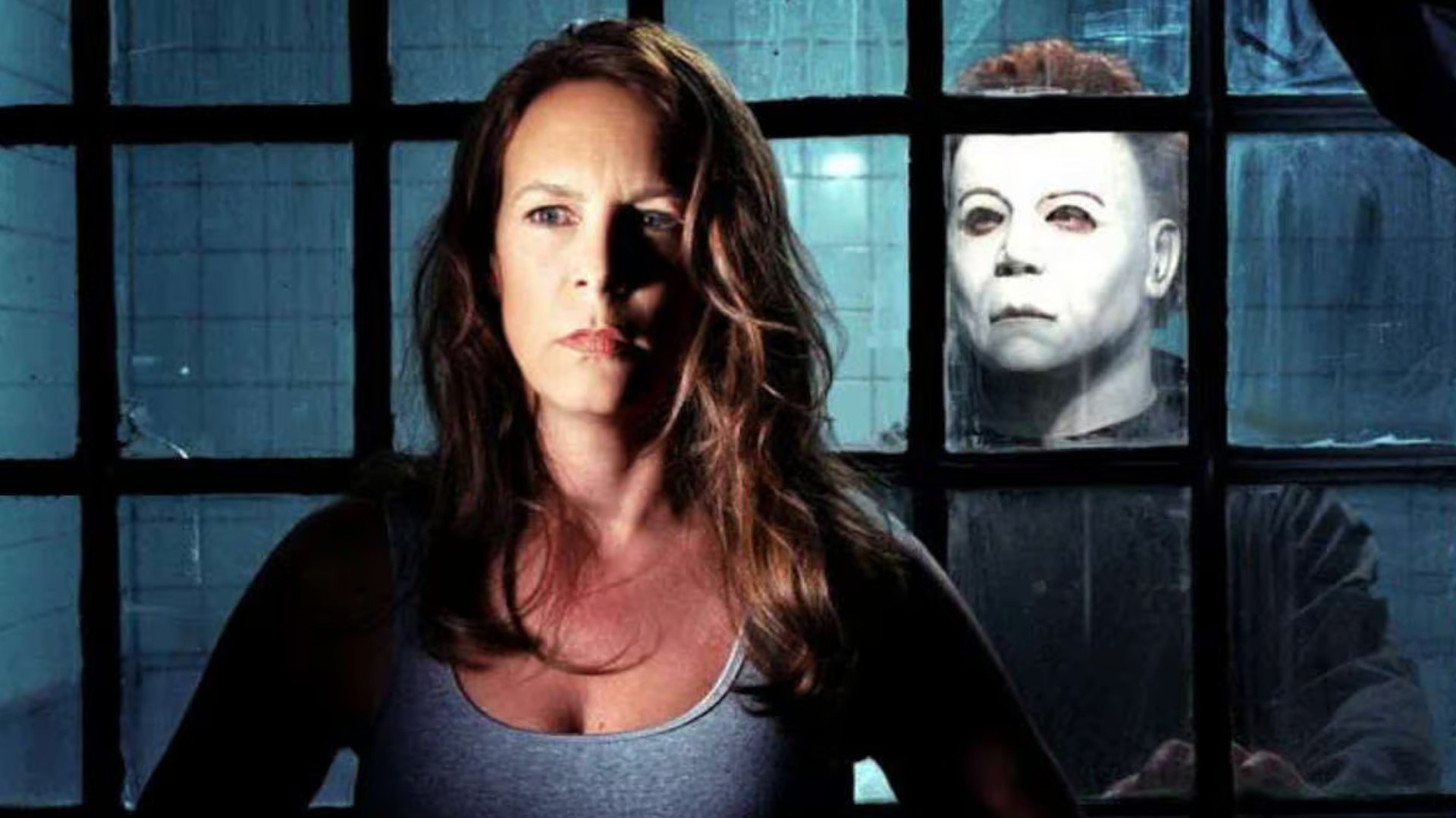 Jamie Lee Curtis as Laurie Strode with Michael Myers behind her during Halloween Resurrection.