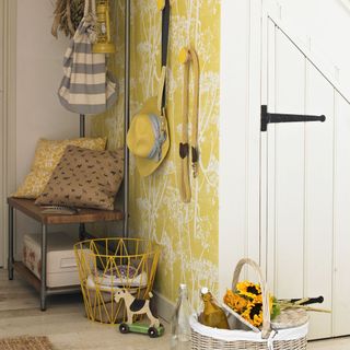 A hallway with a yellow feature wall wallpaper and open storage unit