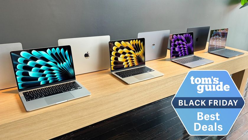 MacBook deals on a table with Black Friday best deals tag superimposed