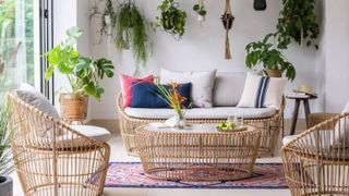 A room with rattan furniture and hanging plants