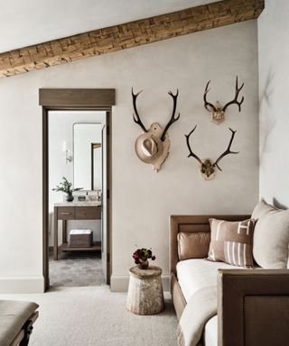 rustic seating area with three antler mounts hung on the wall