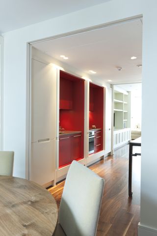 red kitchen hidden behind white pocket doors
