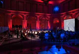 live orchestra performing in red and blue lighting
