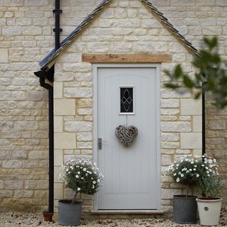 house exterior with white door and pots and heart shape wreath