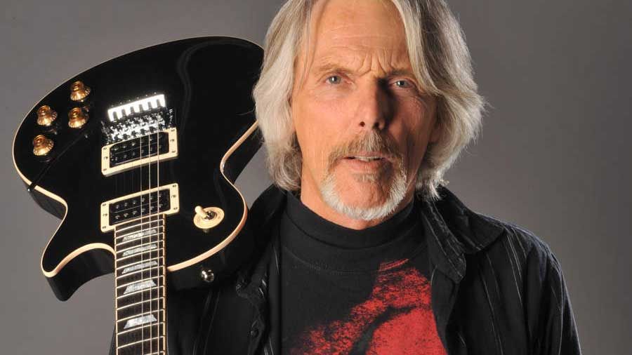 Scott Gorham holding a guitar