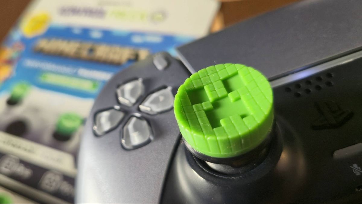 Photo by Rosalie Newcombe of the Creeper thumbstick attached to the left stick of the silver PS5 DualSense controller.