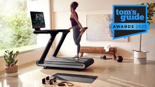 Tom's Guide Awards 2023: Woman stretching on a Peloton Tread during workout
