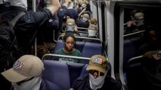 A solitary Black woman rides the train with members of the white supremacist Patriot Front.