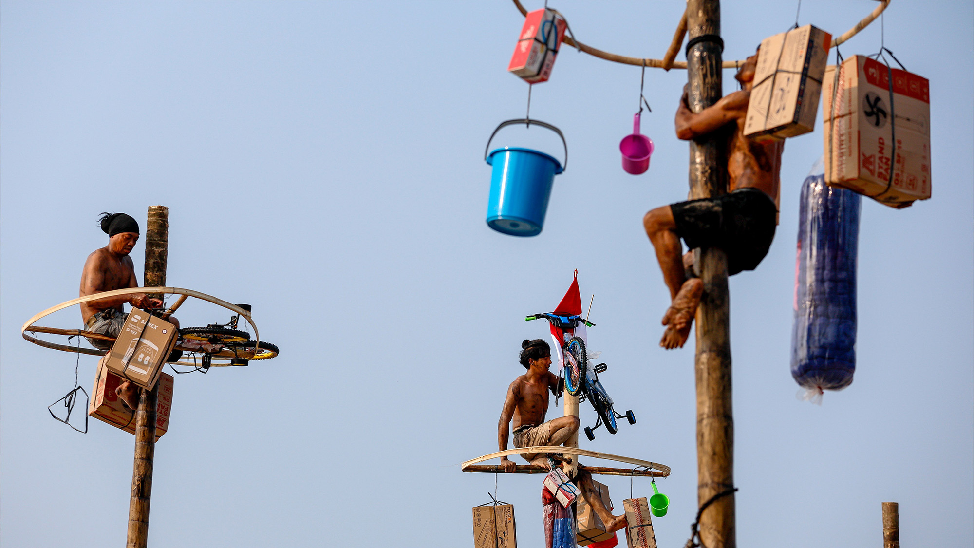 Participants climb during a greased pole race to mark the 81st anniversary of Indonesia's Independence Day in Jakarta, Indonesia