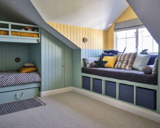 Blue and yellow boys bedroom with bunk beds in Cornish coastal newbuild