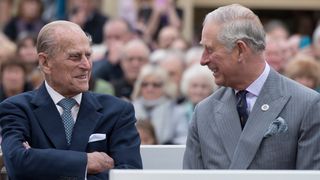 Prince Philip and Prince Charles listen to speeches before a statue of Queen Elizabeth, The Queen Mother was unveiled
