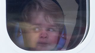Prince George with his face against a window