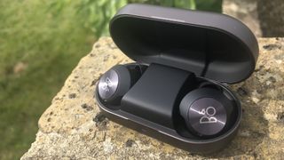 the beoplay eq true wireless earbuds in their charging case