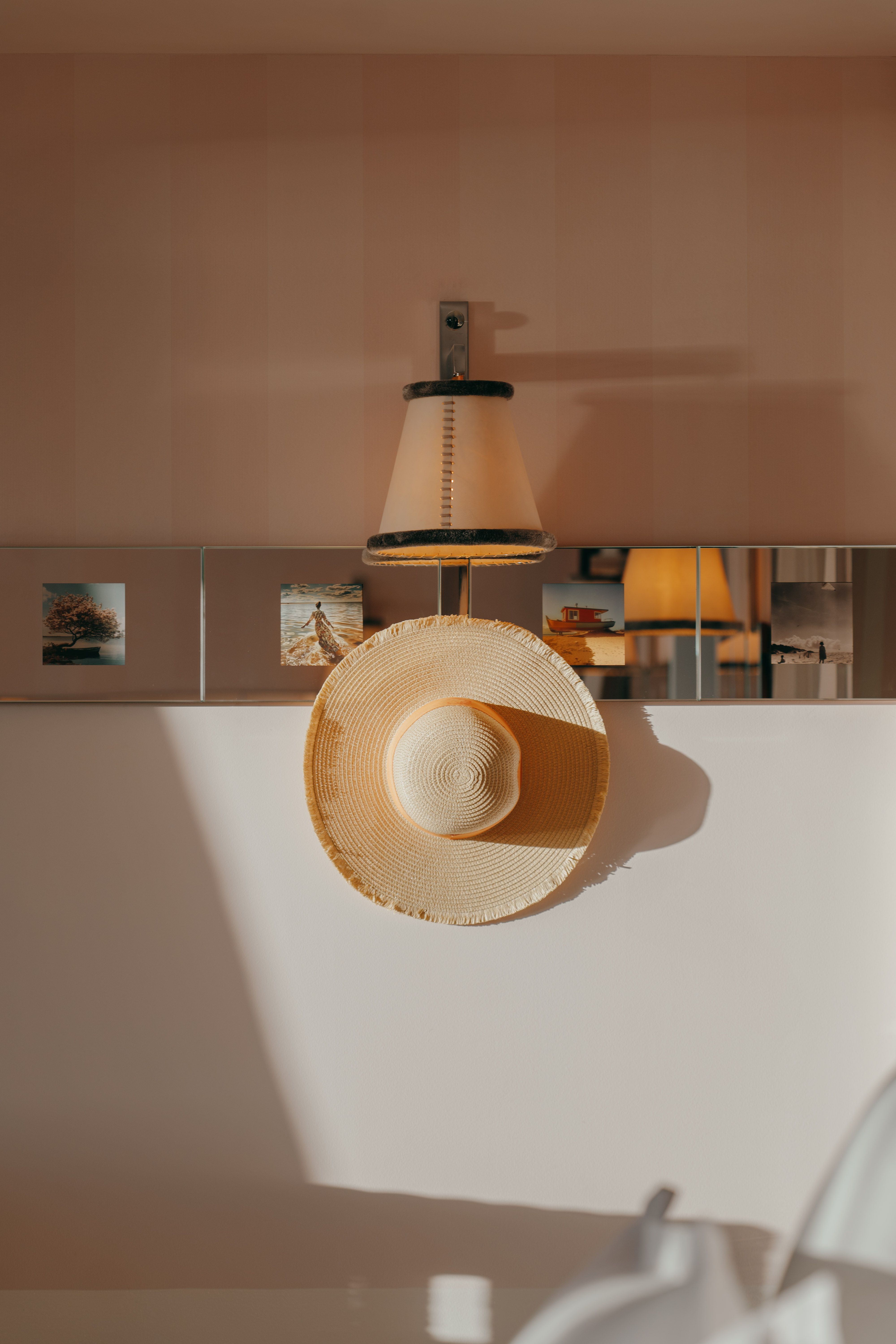 The sun-filled, white-washed interior and exterior of a coastal hotel decorated with modern rustic, elegant furnishings, reflective surfaces, and thriving plants, mimicking the lush outdoors.