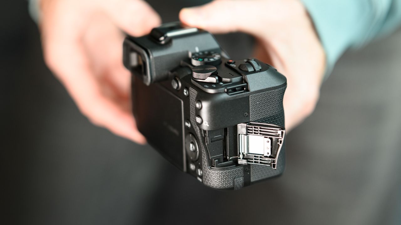 Memory card door of the Canon EOS R8 Mark II, in user's hands