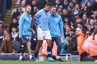 Rodri is helped off the pitch by members of Manchester City's medical staff after suffering a serious injury against Arsenal in the Premier League in September 2024.