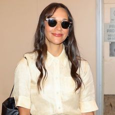 Rashida Jones wears sunglasses and a yellow button-down shirt