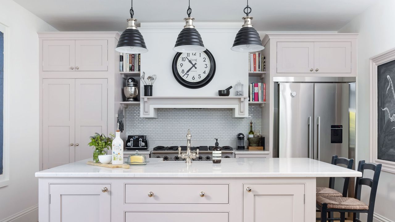 Pink painted kitchen with marble work tops in modern Georgian home 