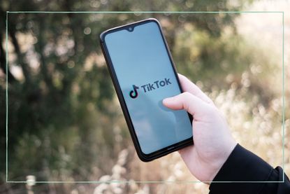 A close up of a phone displaying the TikTok logo